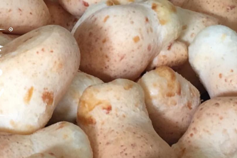 Pães de queijo assados quentinhos com superfície dourada e crocante